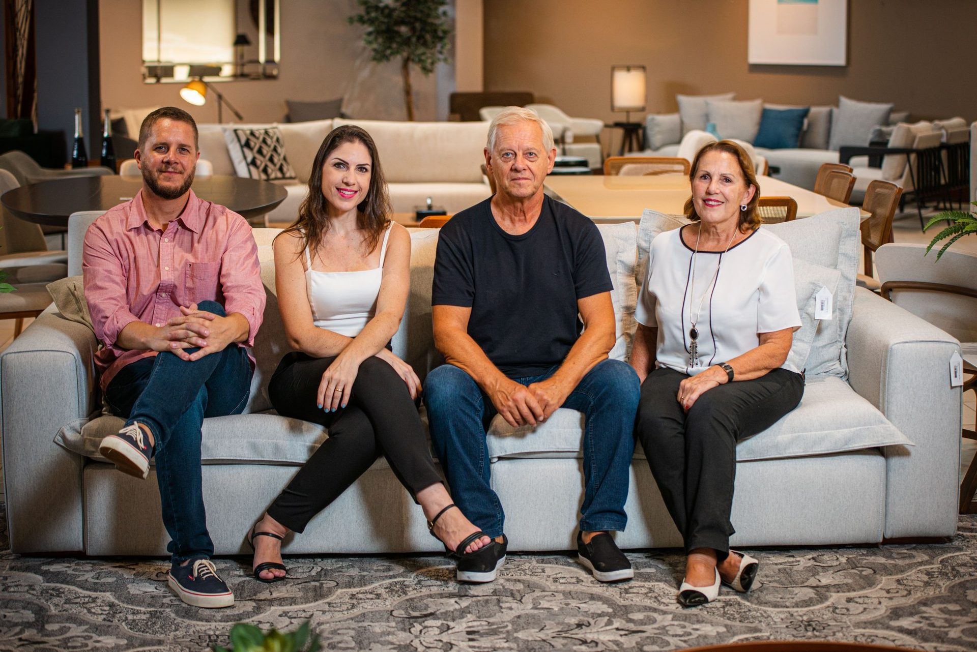 Quatro pessoas sentadas em um sofá no showroom da Reinheimer